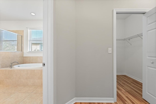 bathroom featuring hardwood / wood-style floors and tiled bath