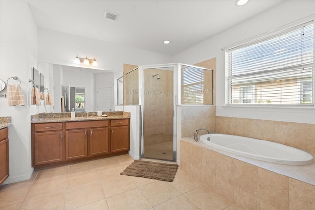 bathroom featuring tile patterned flooring, vanity, plus walk in shower, and a wealth of natural light