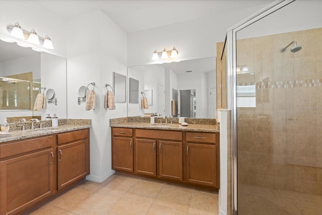 bathroom with tile patterned flooring, vanity, and a shower with door