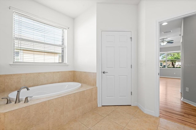 bathroom featuring tile patterned floors, ceiling fan, and tiled tub