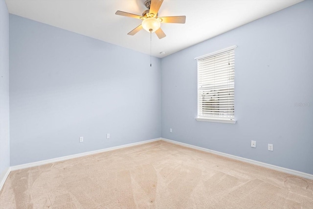 spare room featuring light carpet and ceiling fan