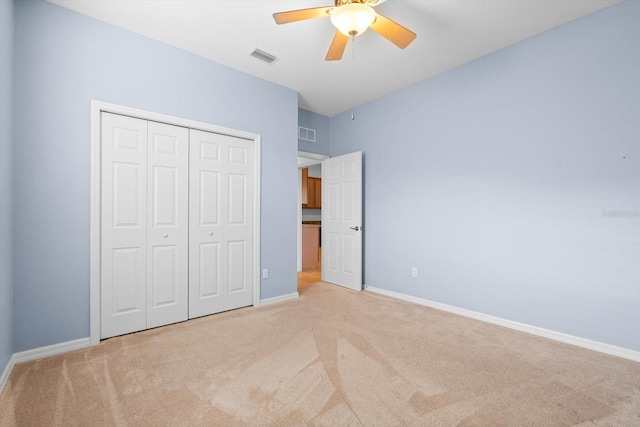 unfurnished bedroom with light carpet, a closet, and ceiling fan