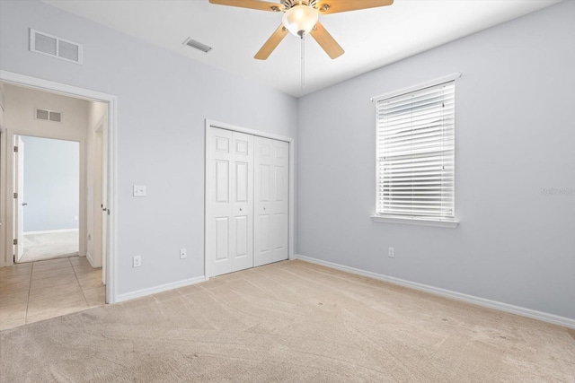 unfurnished bedroom featuring light carpet, a closet, and ceiling fan