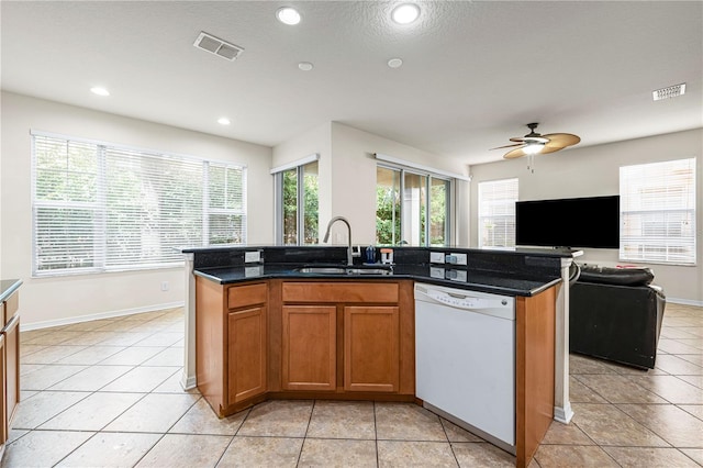 kitchen with a center island with sink, dishwasher, a healthy amount of sunlight, and sink