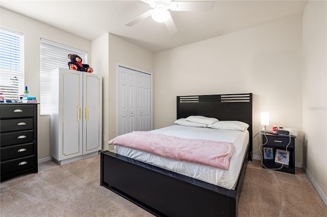 bedroom with ceiling fan, a closet, and light colored carpet