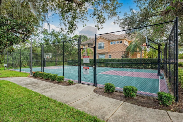 view of sport court with a lawn