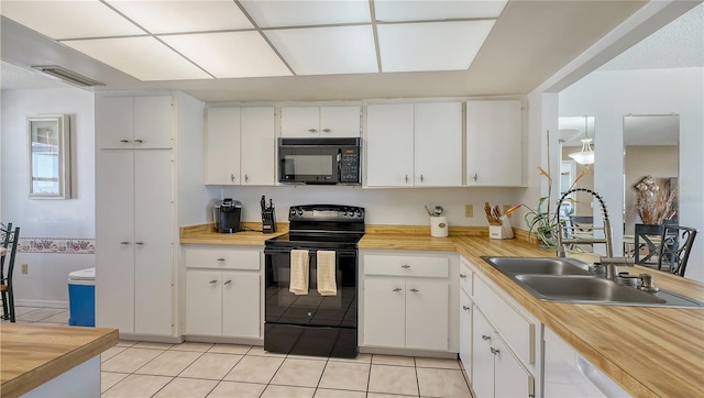 kitchen featuring white cabinets, light tile patterned floors, sink, and black appliances