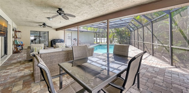 sunroom featuring ceiling fan, a wealth of natural light, and a swimming pool