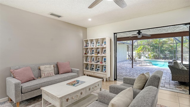 tiled living room with a textured ceiling and ceiling fan