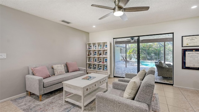 tiled living room with ceiling fan and a textured ceiling