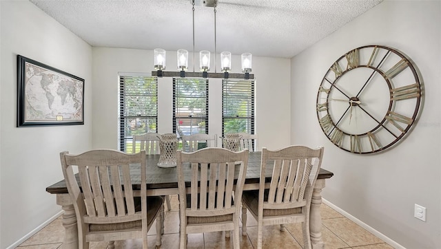 tiled dining space featuring a textured ceiling and an inviting chandelier