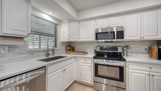 kitchen with appliances with stainless steel finishes, white cabinetry, and sink