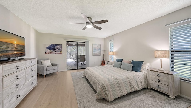 bedroom featuring ceiling fan, a textured ceiling, access to outside, and light hardwood / wood-style flooring