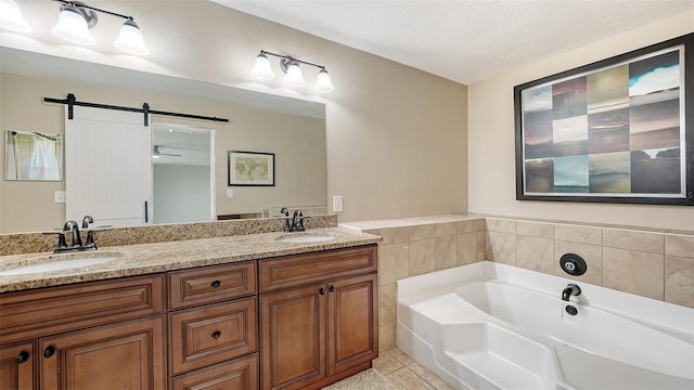 bathroom with vanity, tile patterned flooring, ceiling fan, a textured ceiling, and a tub