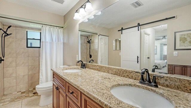 bathroom with a shower with curtain, vanity, toilet, and tile patterned floors