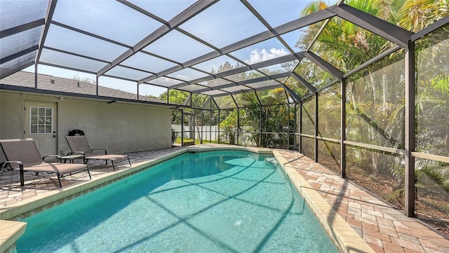 view of swimming pool featuring a lanai and a patio area