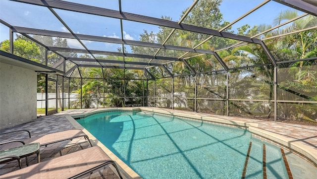 view of pool featuring glass enclosure and a patio area