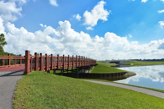 view of home's community with a water view and a yard