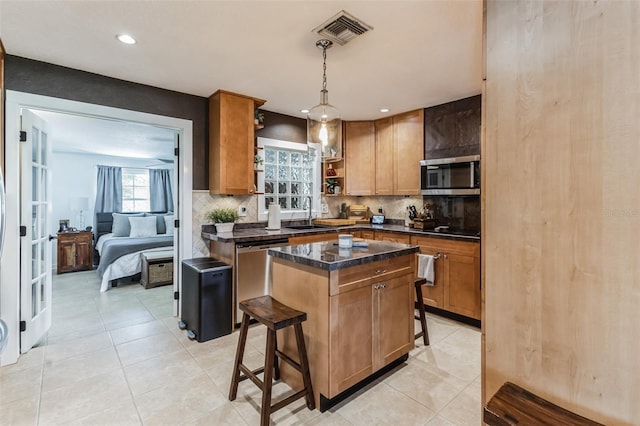 kitchen with decorative backsplash, a kitchen breakfast bar, stainless steel appliances, decorative light fixtures, and a kitchen island