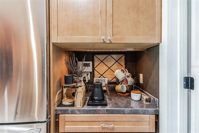 room details with light brown cabinetry and stainless steel refrigerator