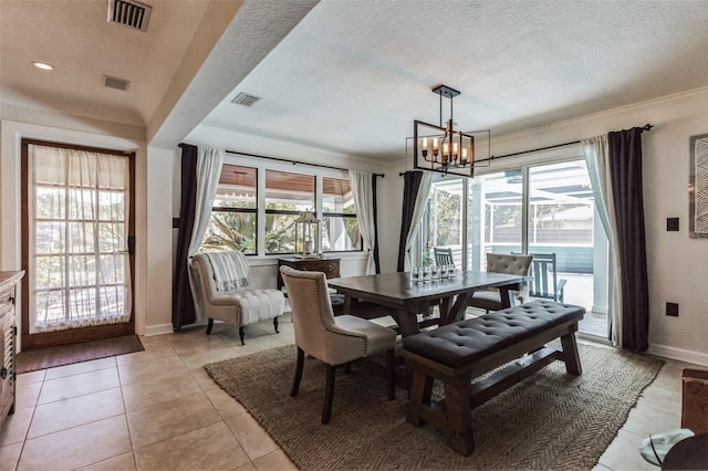 dining area featuring light tile patterned floors, a textured ceiling, a wealth of natural light, and a notable chandelier