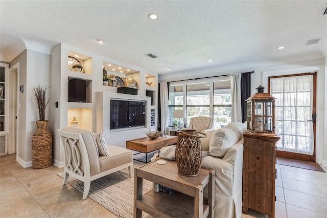 tiled living room with built in shelves and a textured ceiling