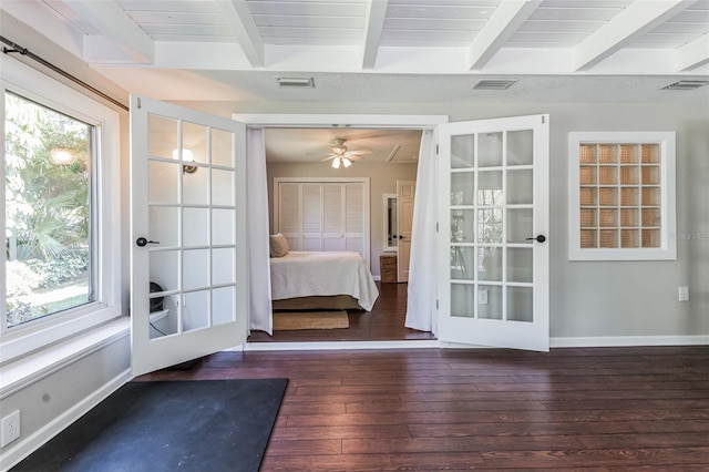 unfurnished bedroom featuring beamed ceiling, french doors, dark hardwood / wood-style floors, and multiple windows