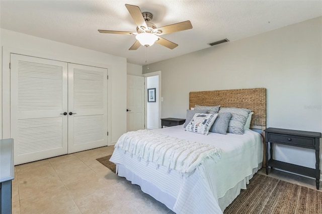 tiled bedroom featuring ceiling fan, a closet, and a textured ceiling