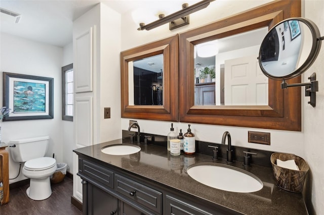 bathroom with vanity, wood-type flooring, and toilet