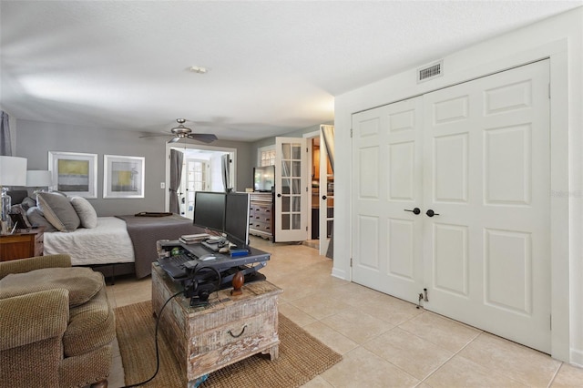 bedroom with ceiling fan, light tile patterned flooring, and a closet