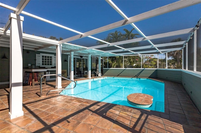 view of swimming pool featuring a patio and a lanai