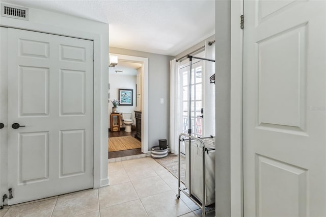 interior space with light tile patterned floors and a textured ceiling