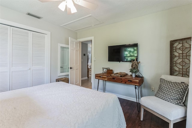 bedroom featuring ceiling fan, a closet, dark wood-type flooring, and a textured ceiling