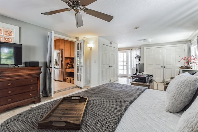 bedroom featuring ceiling fan, french doors, stainless steel refrigerator with ice dispenser, and multiple windows