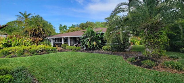 view of front facade featuring a sunroom and a front yard