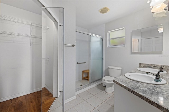 bathroom featuring walk in shower, tile patterned flooring, vanity, and toilet