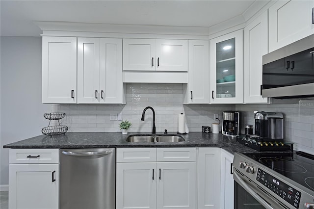 kitchen with decorative backsplash, appliances with stainless steel finishes, white cabinetry, and sink