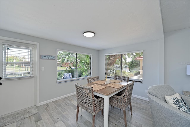 dining space with light wood-type flooring and plenty of natural light