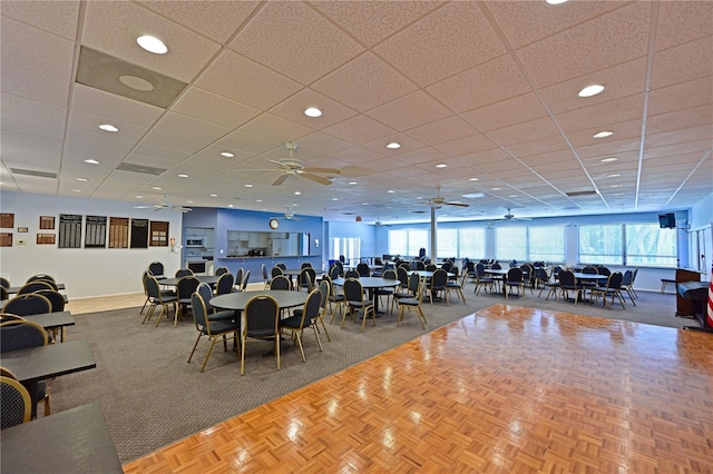 dining room with ceiling fan and a drop ceiling