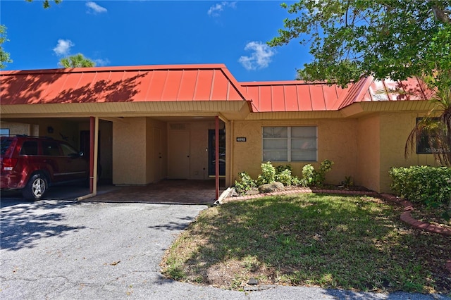 view of front of house featuring a carport and a front lawn