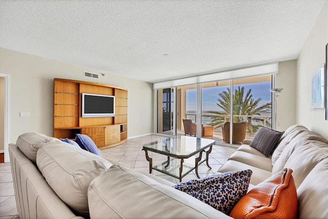 1800 Benjamin Franklin Dr Unit A304, Sarasota, FL 34236 - living room featuring light tile patterned flooring, a textured ceiling, and baseboards