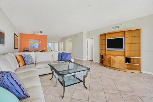 1800 Benjamin Franklin Dr Unit A304, Sarasota, FL 34236 - living room featuring light tile patterned flooring, a textured ceiling, baseboards, and built in shelves
