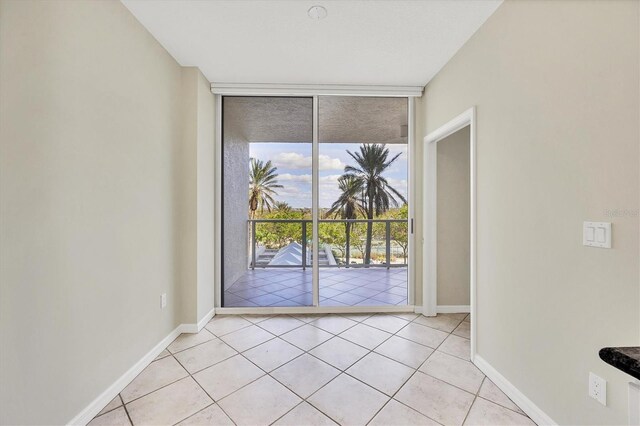 1800 Benjamin Franklin Dr Unit A304, Sarasota, FL 34236 - empty room with expansive windows, light tile patterned flooring, and baseboards