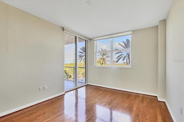 1800 Benjamin Franklin Dr Unit A304, Sarasota, FL 34236 - spare room featuring wood finished floors, baseboards, and a textured ceiling