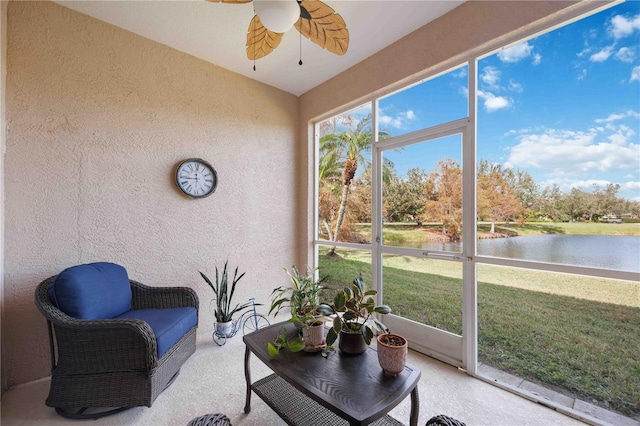 sunroom / solarium featuring a water view and ceiling fan