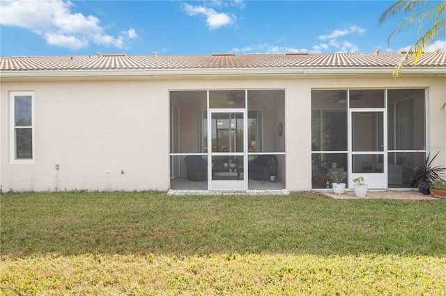 4209 Cascade Falls Dr, Sarasota, FL 34243 - back of property with stucco siding, a sunroom, and a lawn