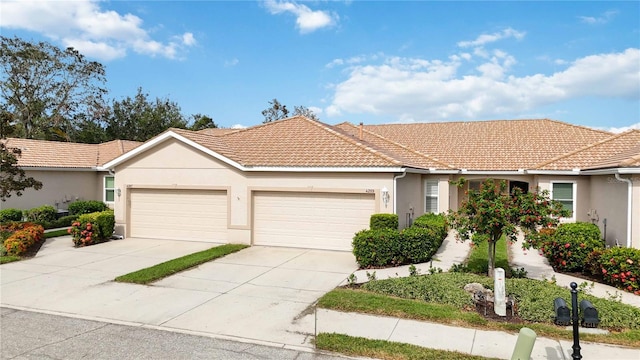 4209 Cascade Falls Dr, Sarasota, FL 34243 - view of front of property featuring an attached garage, stucco siding, a tile roof, and driveway