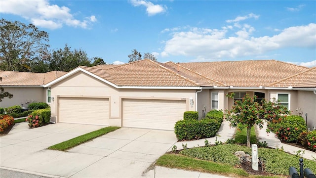 4209 Cascade Falls Dr, Sarasota, FL 34243 - ranch-style house featuring an attached garage, a tile roof, stucco siding, and driveway