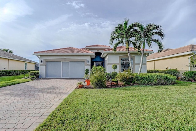 mediterranean / spanish house featuring a garage and a front lawn