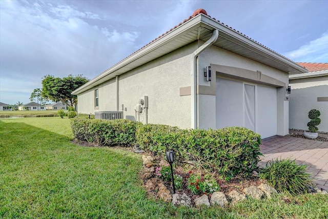 view of property exterior featuring central AC unit and a lawn